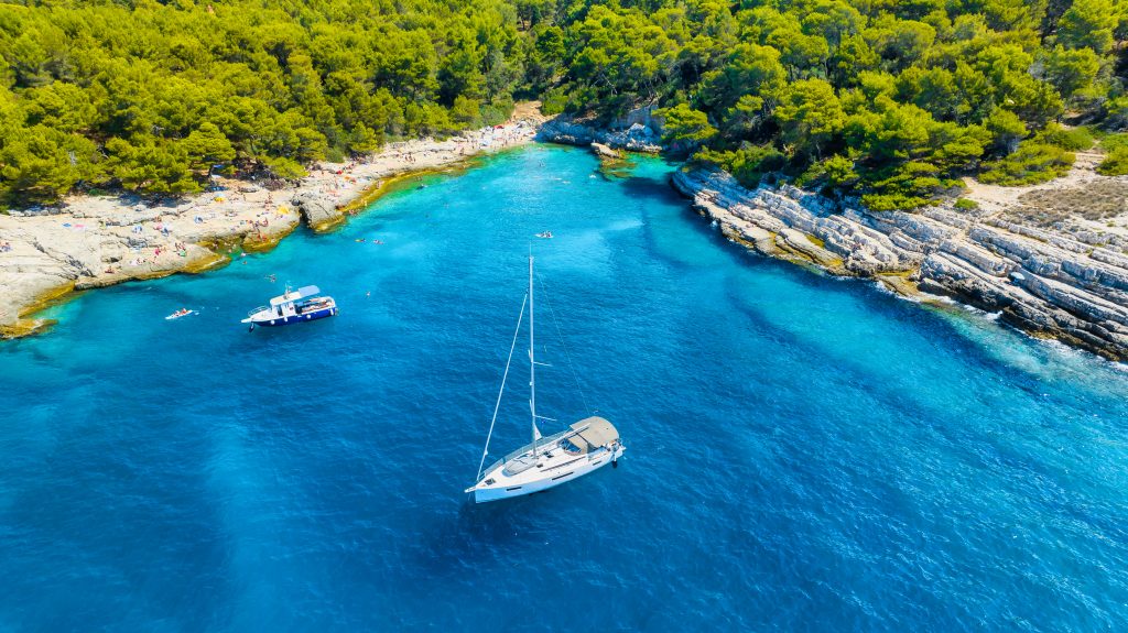 Motorboat vs Sailboat close to a beautifull beach in Istria during a private boat tour