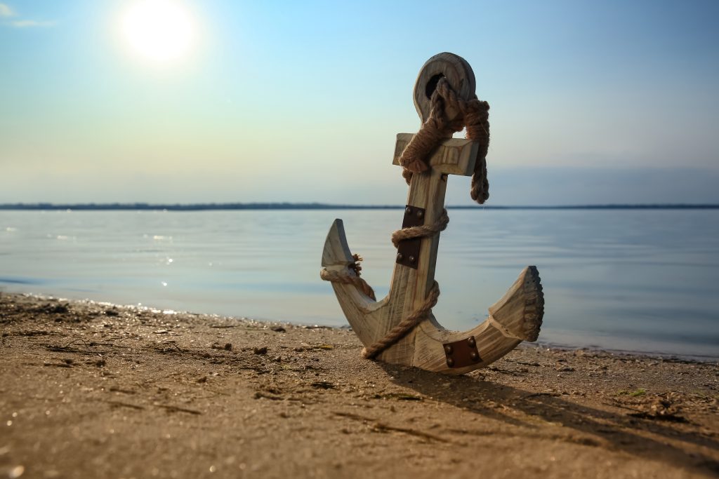 wooden anchor on the river shore